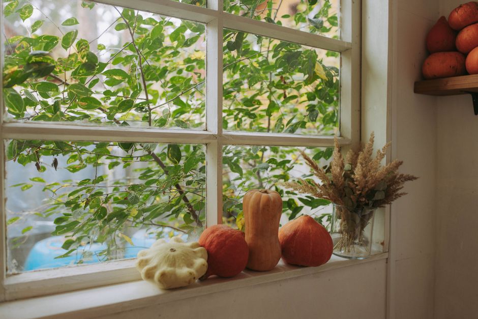 Herfst decor met ingebouwde plantenbakken op vensterbank.